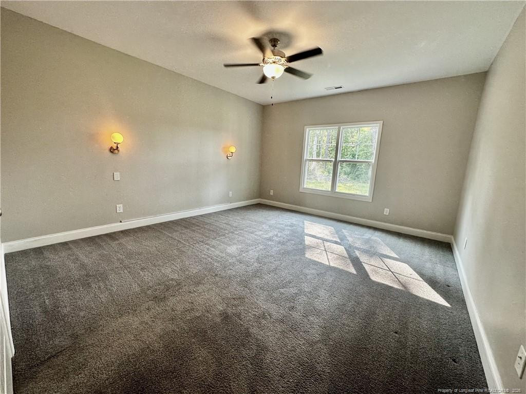 5177 Maxwell Road Stedman, NC 28391 - Photo 16 of 24 an empty room with windows and ceiling fan