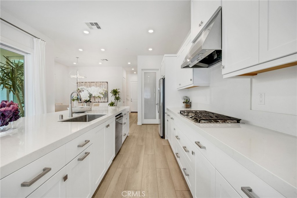 1109 Cadence Irvine, CA 92618 - Photo 4 of 12 a large kitchen with stainless steel appliances granite countertop a lot of counter space and wooden floors