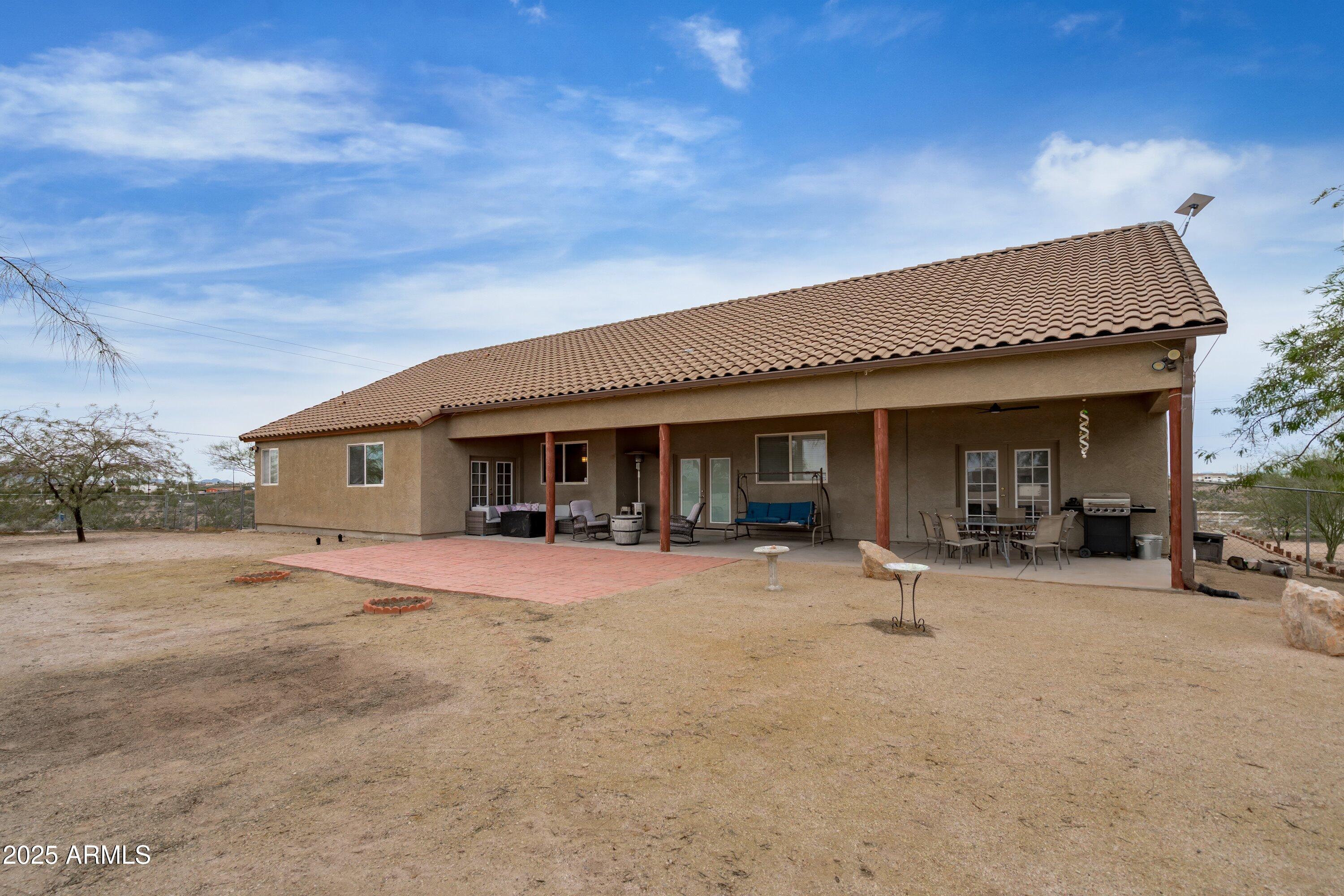 35947 West Buckeye Road Tonopah, AZ 85354 - Photo 40 of 54 a patio with a table and chairs under an umbrella