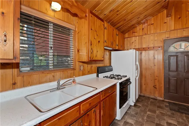 a kitchen that has a sink a stove and a refrigerator