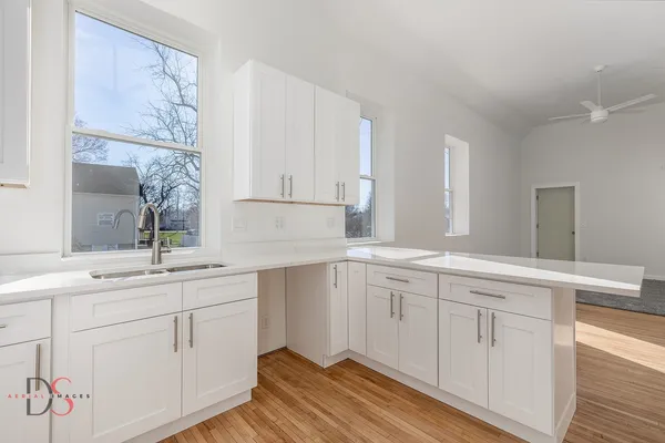 a kitchen with sink cabinets and wooden floor