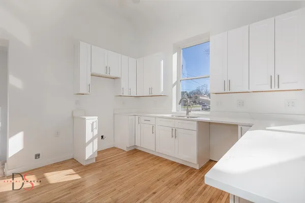 a kitchen with white cabinets and sink