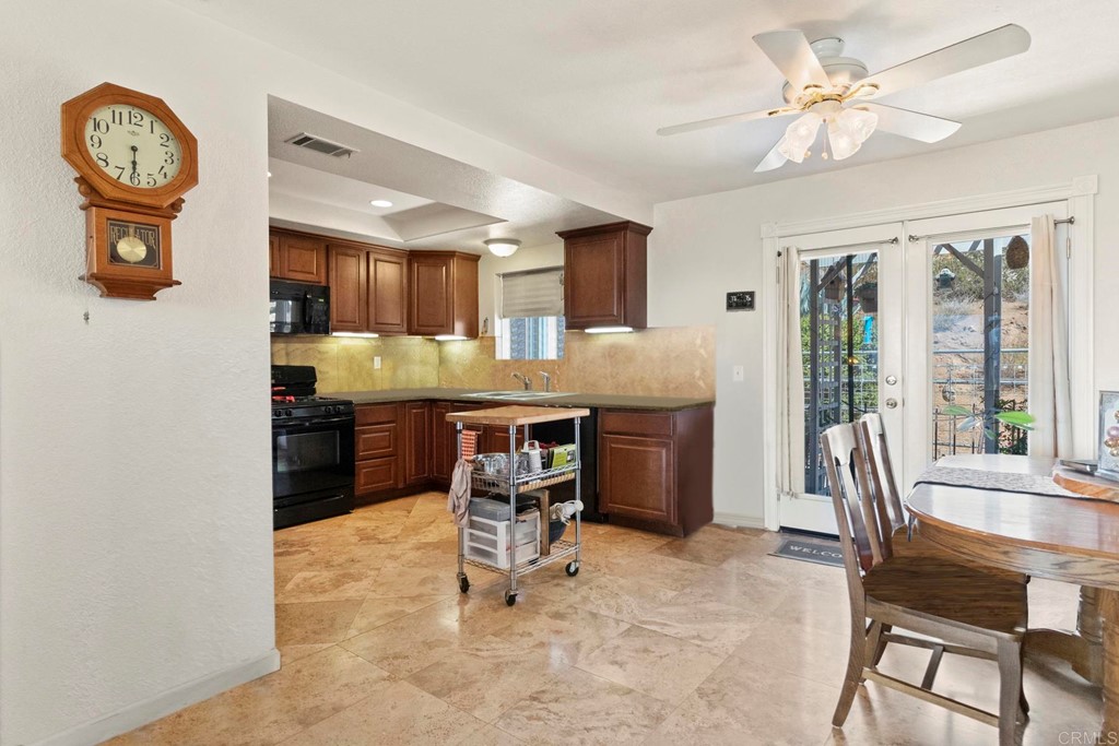 1104 Doomey Drive Ramona, CA 92065 - Photo 11 of 31 a dining hall with stainless steel appliances kitchen island granite countertop furniture and a large window
