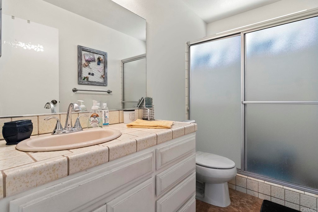 1104 Doomey Drive Ramona, CA 92065 - Photo 18 of 31 a bathroom with a granite countertop sink mirror vanity and toilet