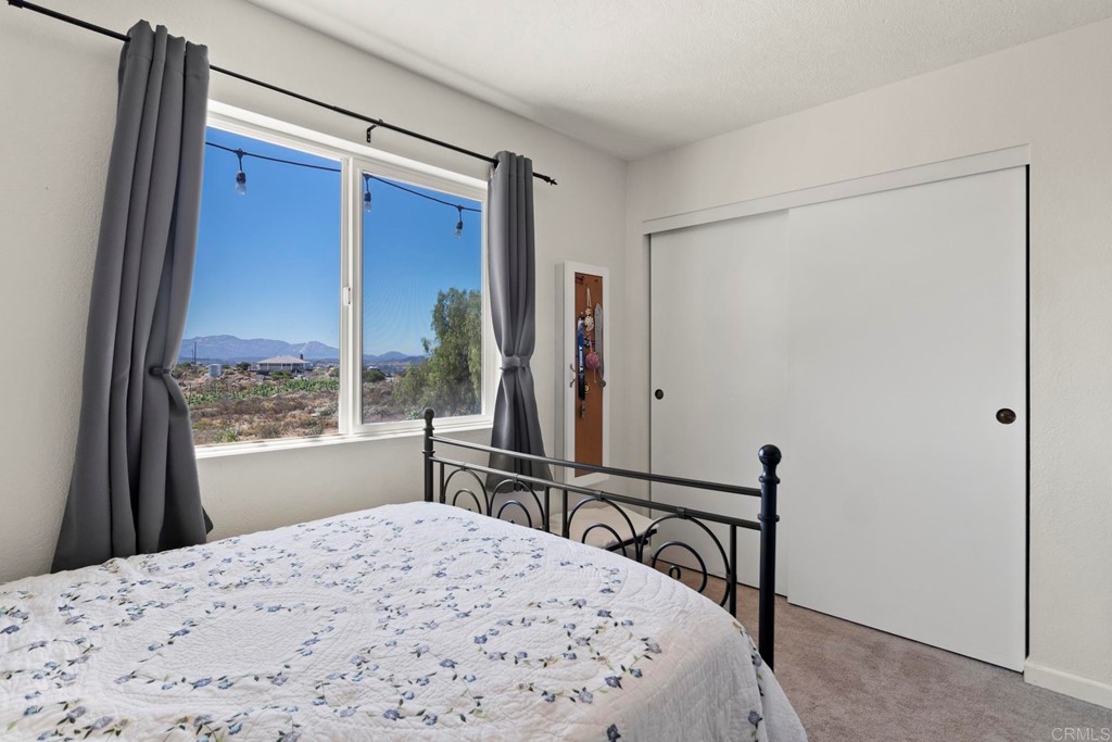 1104 Doomey Drive Ramona, CA 92065 - Photo 22 of 31 a bedroom with a bed window and a table