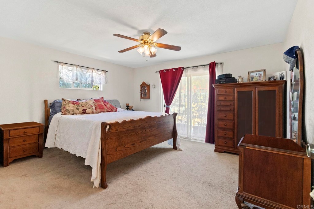 1104 Doomey Drive Ramona, CA 92065 - Photo 23 of 31 a bedroom with a bed and a chandelier