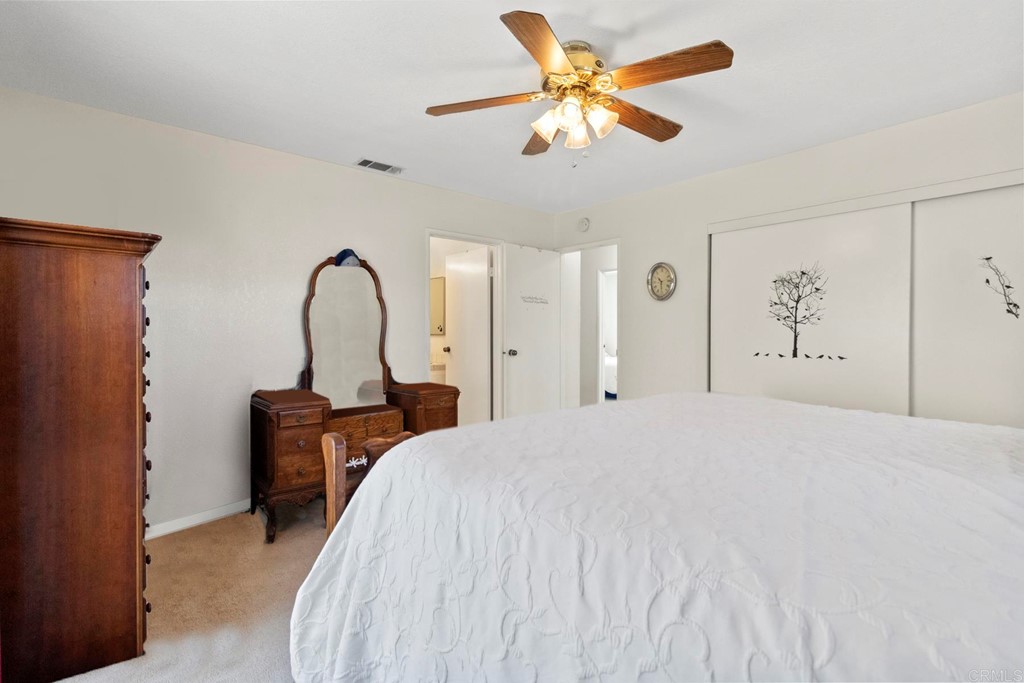 1104 Doomey Drive Ramona, CA 92065 - Photo 24 of 31 a bedroom with a bed and a chandelier