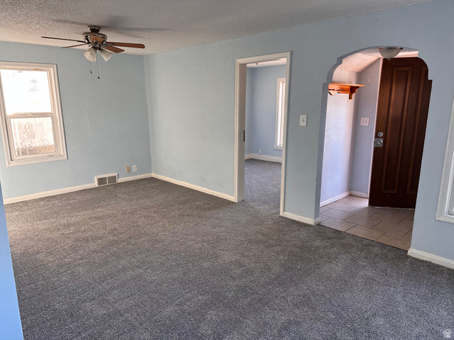 154 East Harris Street Ogden, UT 84401 - Photo 9 of 10 Spare room with arched walkways, carpet, ceiling fan, and a textured ceiling