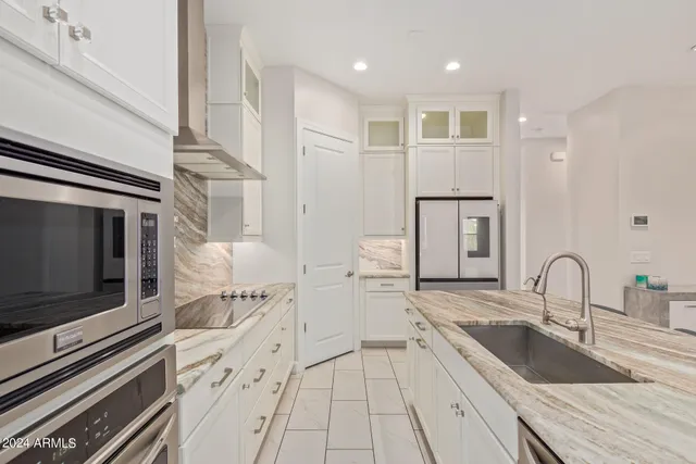 a kitchen with stainless steel appliances granite countertop a kitchen island hardwood floor sink and stove