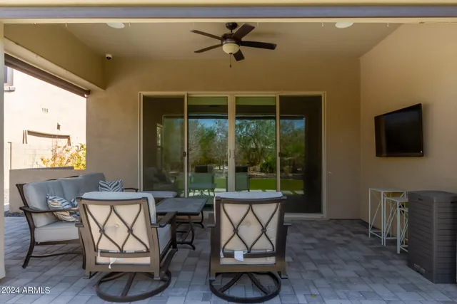 a living room with furniture a flat screen tv and a large window