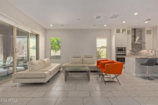 a living room with furniture a fireplace and a large window
