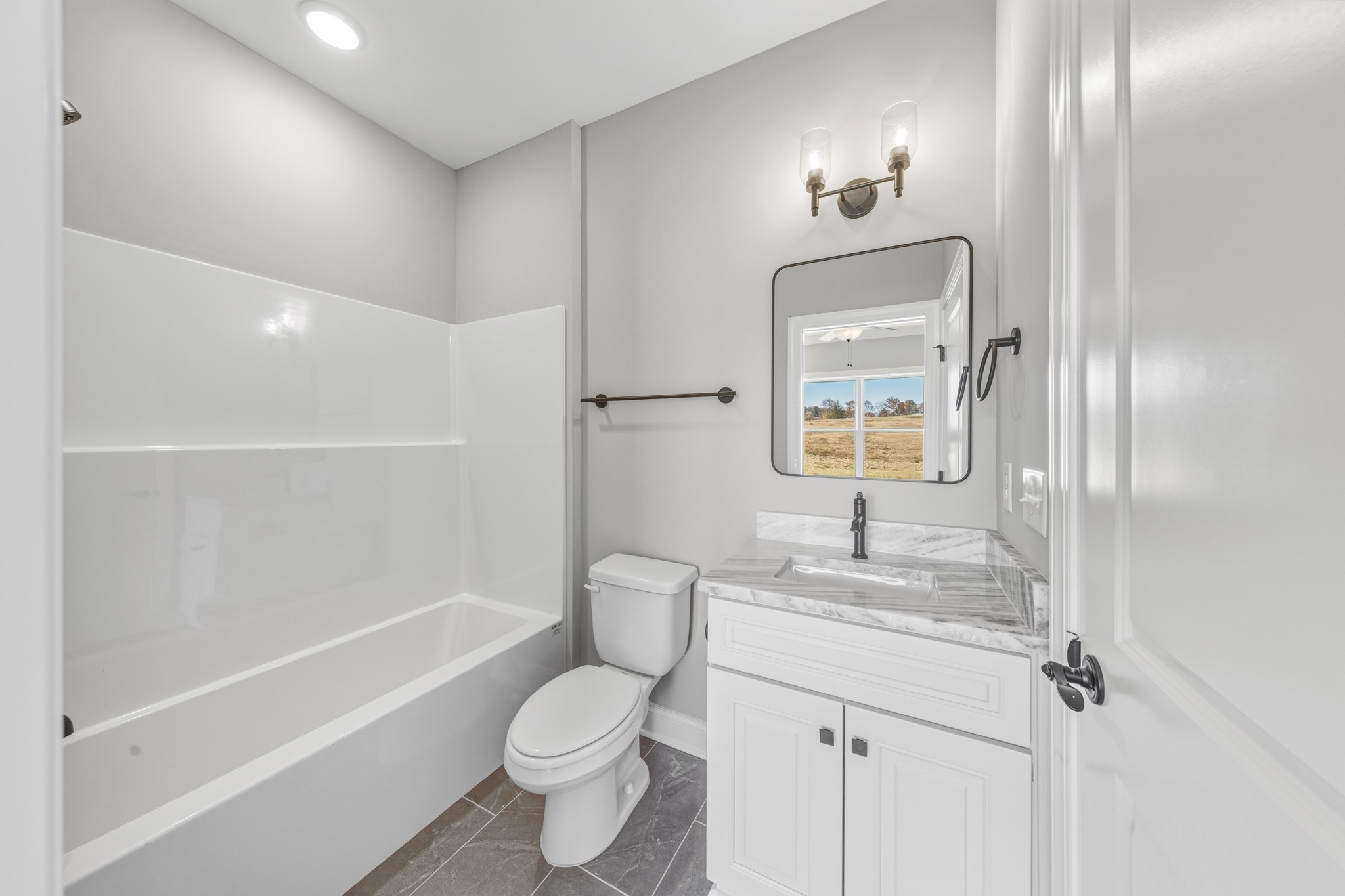 1675 Sulphur College Road Hartsville, TN 37074 - Photo 28 of 42 a bathroom with a granite countertop sink toilet a large mirror a bathtub and shower