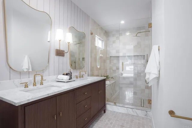 a bathroom with a double vanity sink mirror and shower