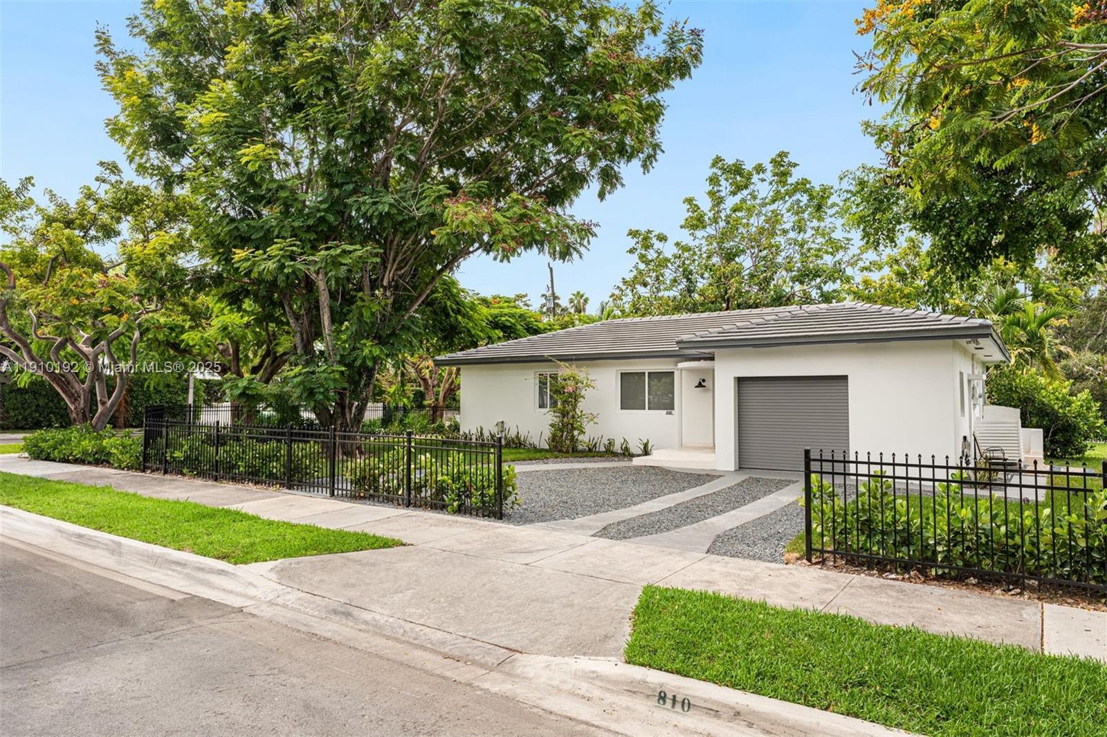 a view of a house with a yard and large trees