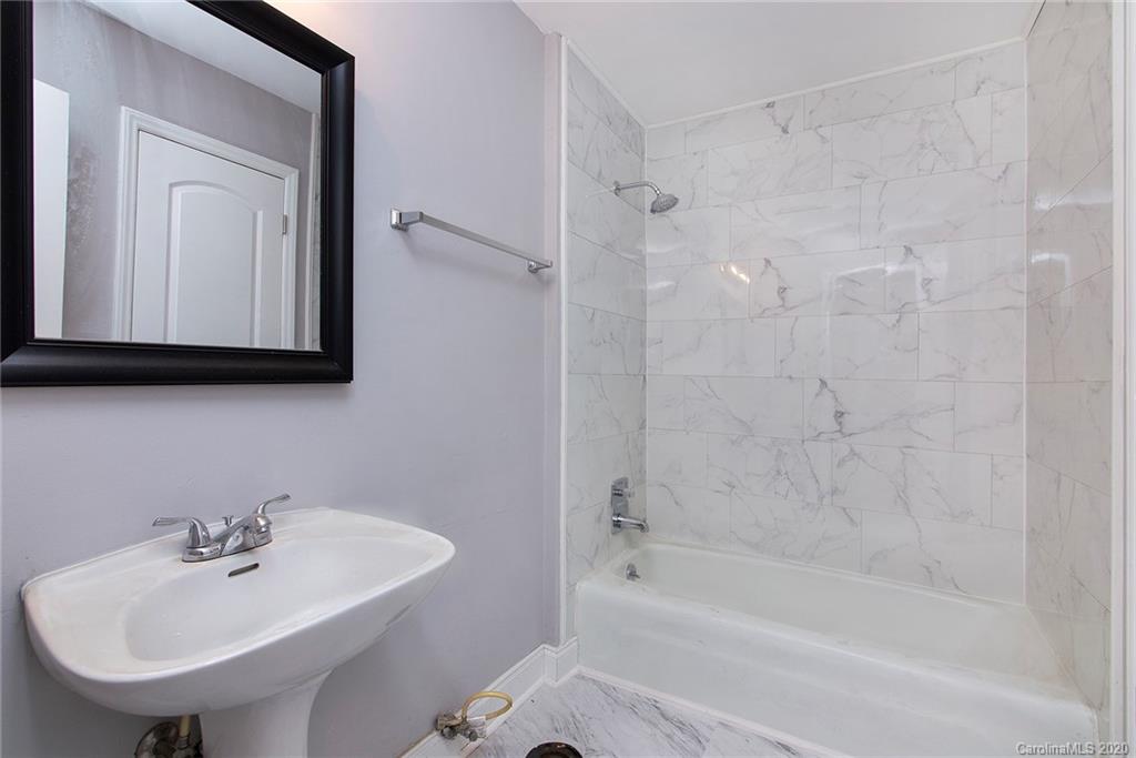5720 Lawrence Orr Road Charlotte, NC 28212 - Photo 15 of 19 a bathroom with a sink a mirror and a bathtub