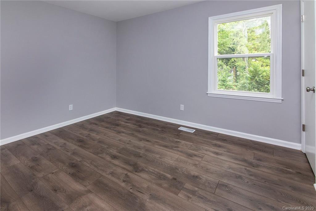 5720 Lawrence Orr Road Charlotte, NC 28212 - Photo 16 of 19 an empty room with wooden floor and windows