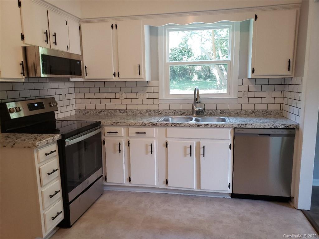 5720 Lawrence Orr Road Charlotte, NC 28212 - Photo 10 of 19 a kitchen with white cabinets and a stove