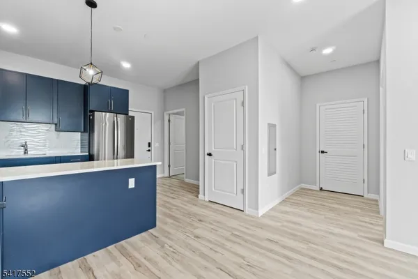 a kitchen with stainless steel appliances a refrigerator and wooden floor