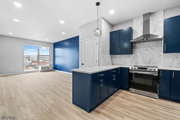 a large kitchen with stainless steel appliances wooden cabinets a stove and a sink