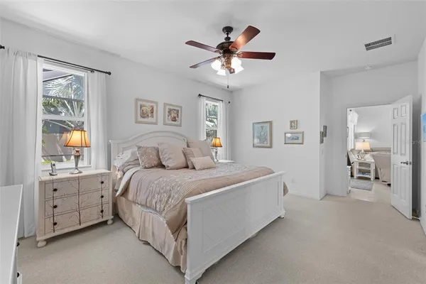 a spacious bedroom with a large bed and a chandelier