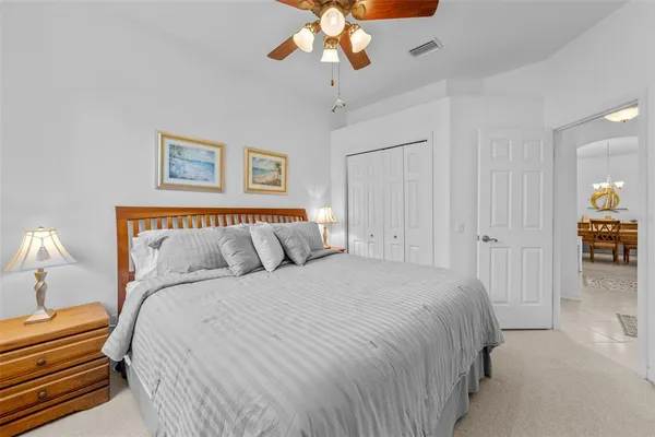 a spacious bedroom with a bed and a chandelier