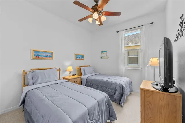 a bedroom with two beds and a flat screen tv