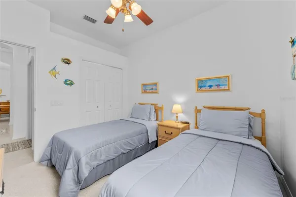 a bedroom with two large bed and a chandelier