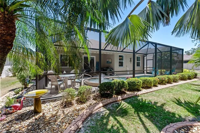 a view of backyard of house with outdoor seating and green space