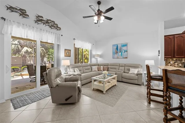 a living room with furniture ceiling fan and a window