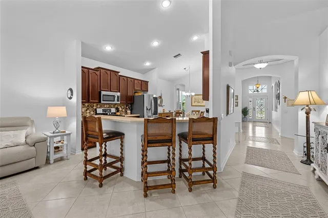 a kitchen with stainless steel appliances kitchen island granite countertop a table and chairs in it