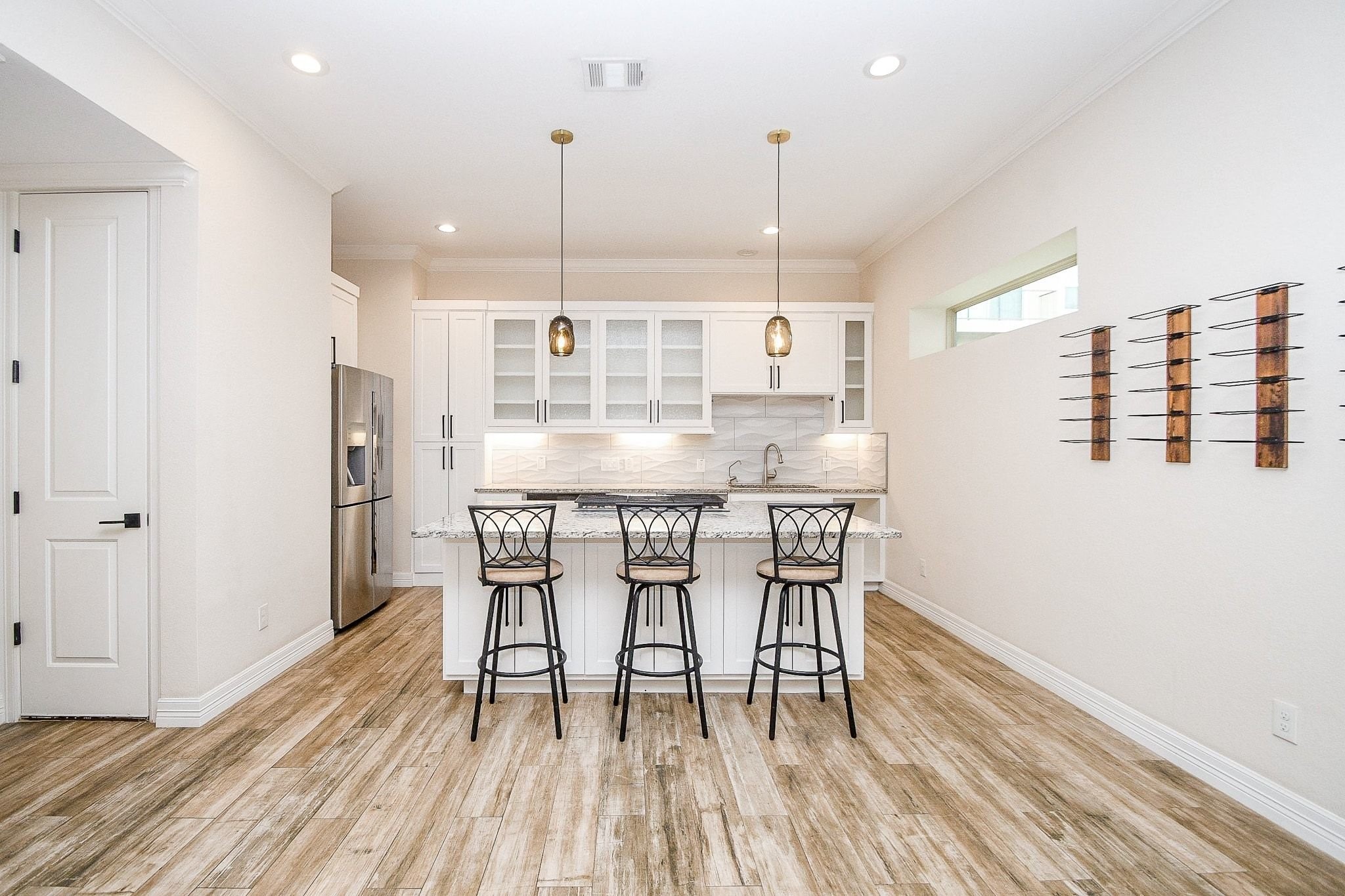 710 Stanford Street, Unit B Houston, TX 77019 - Photo 15 of 33 a room with stainless steel appliances kitchen island granite countertop a table chairs and a wooden floor