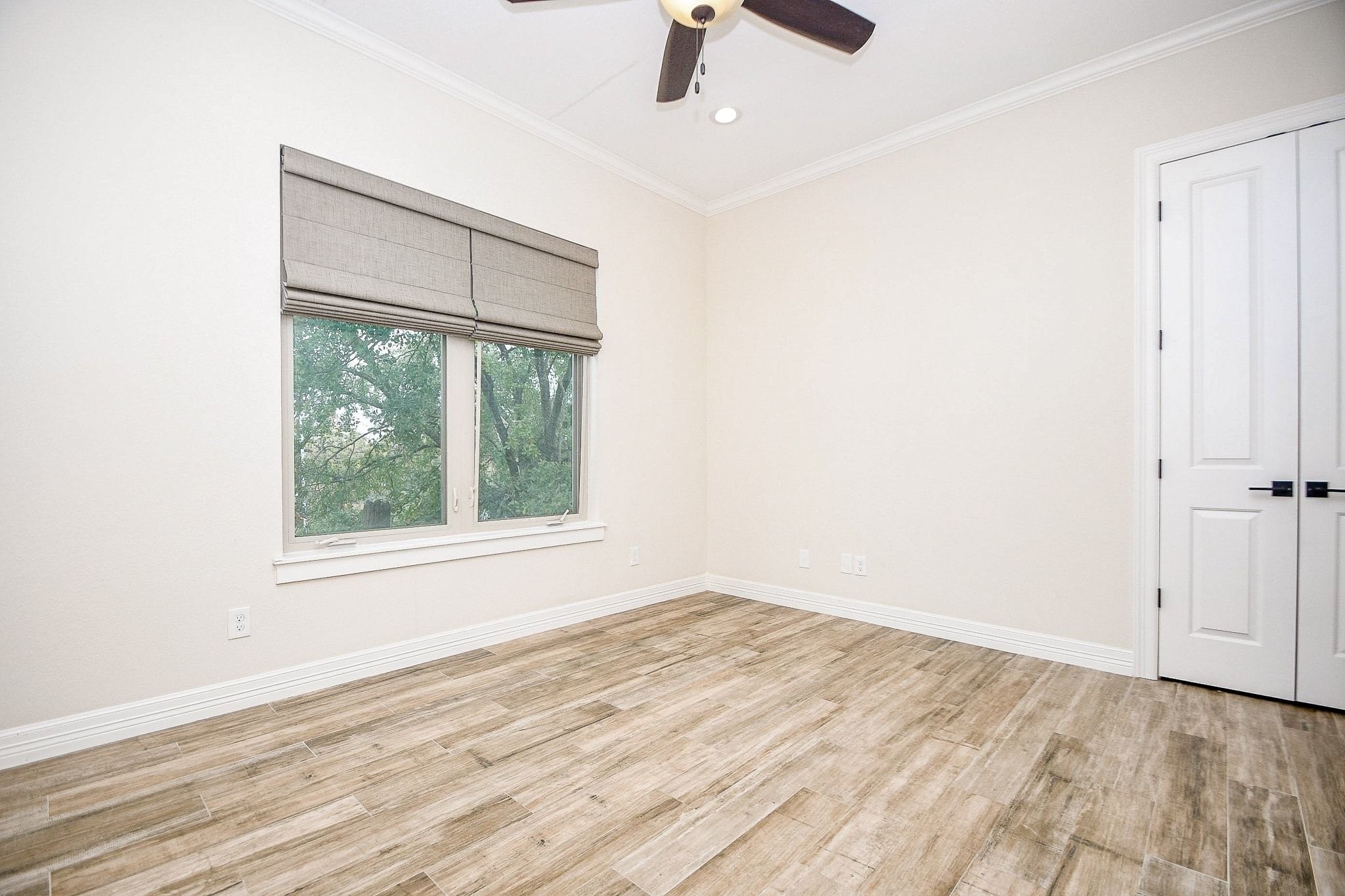 710 Stanford Street, Unit B Houston, TX 77019 - Photo 18 of 33 an empty room with wooden floor fan and windows