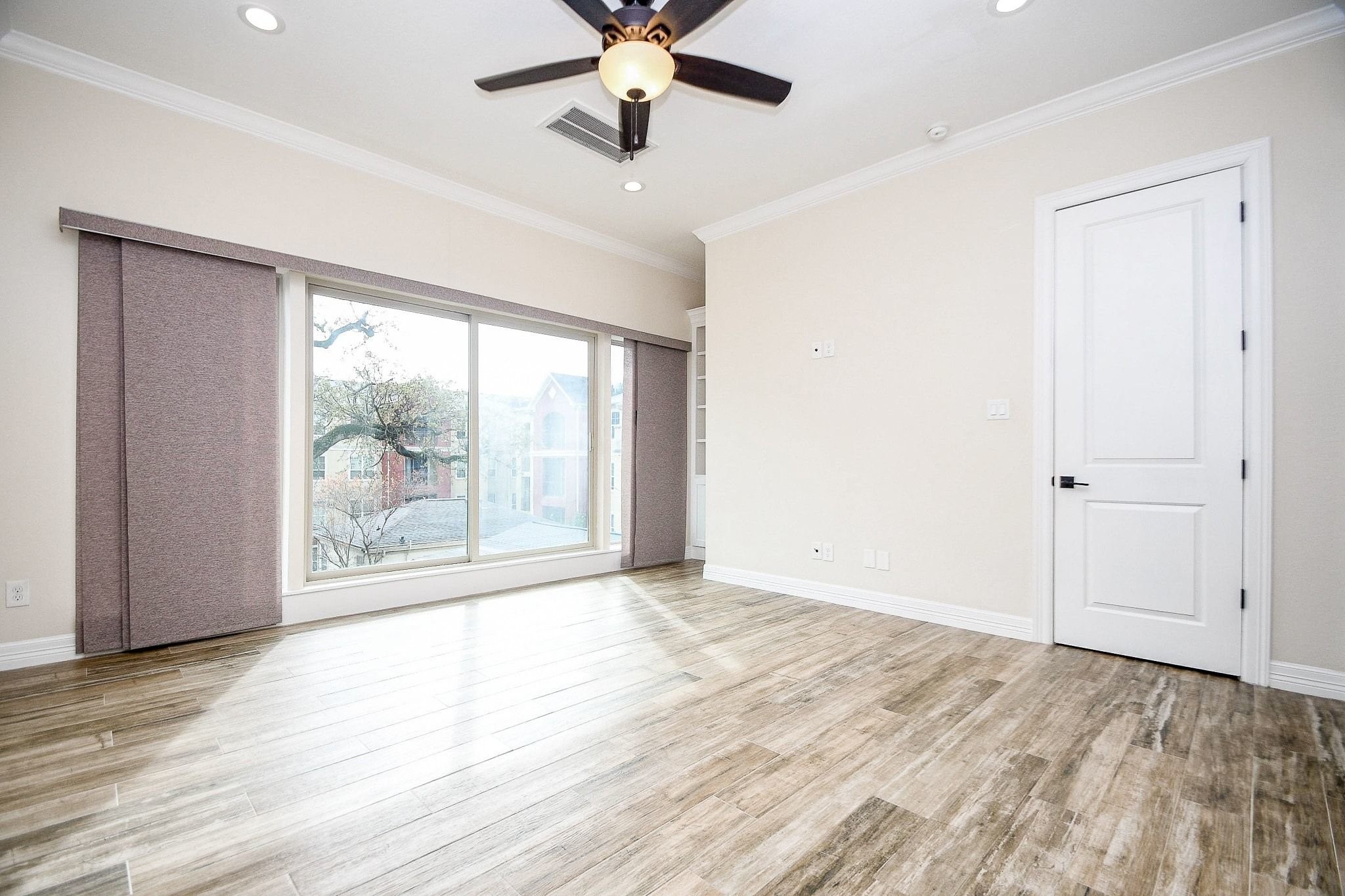 710 Stanford Street, Unit B Houston, TX 77019 - Photo 21 of 33 a view of an empty room with a window and wooden floor