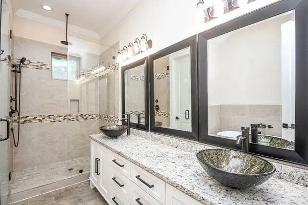 a bathroom with a granite countertop shower and a sink
