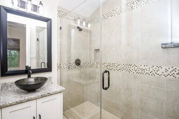 a bathroom with a sink shower and a mirror