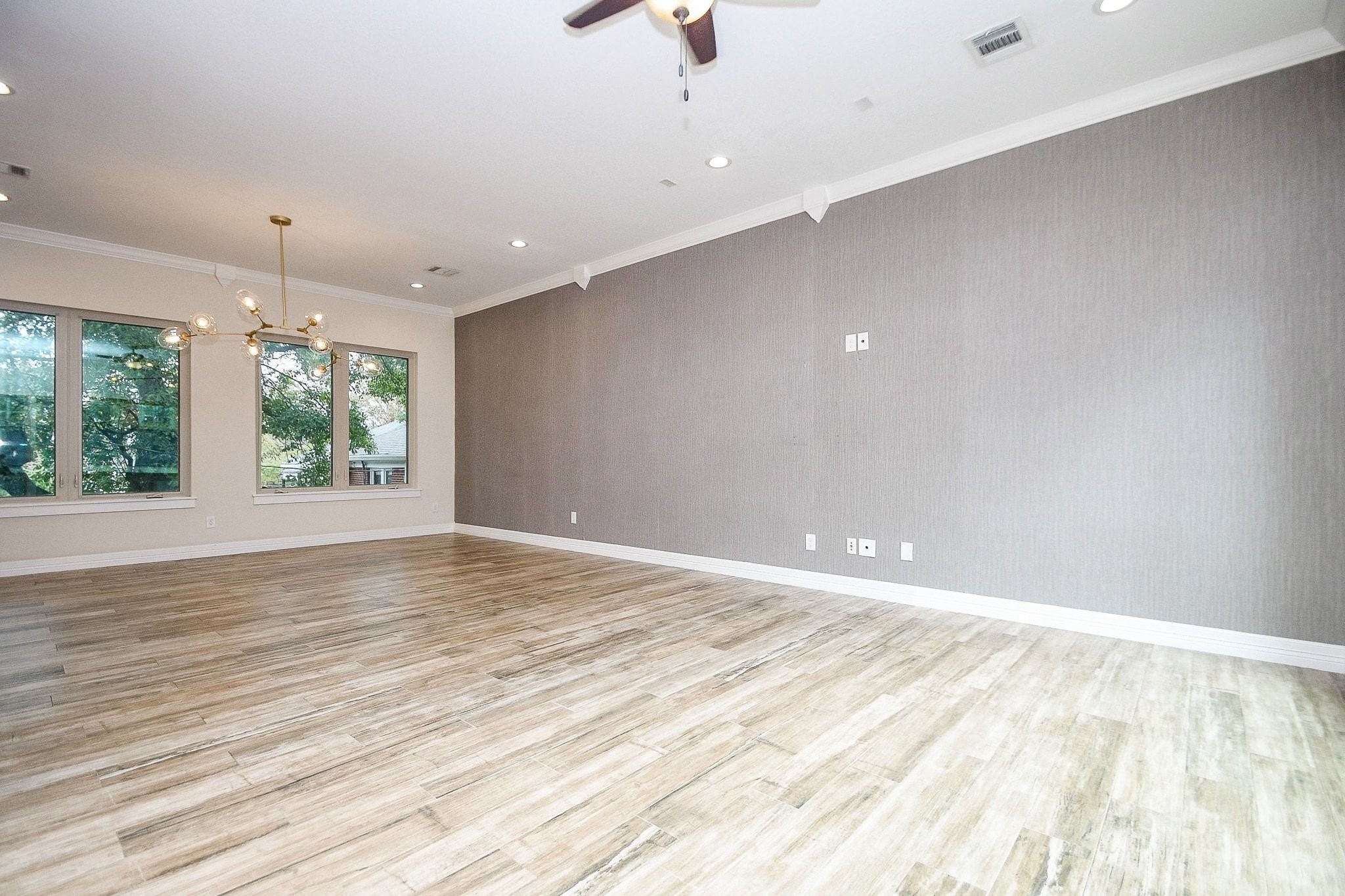 710 Stanford Street, Unit B Houston, TX 77019 - Photo 9 of 33 an empty room with wooden floor and windows