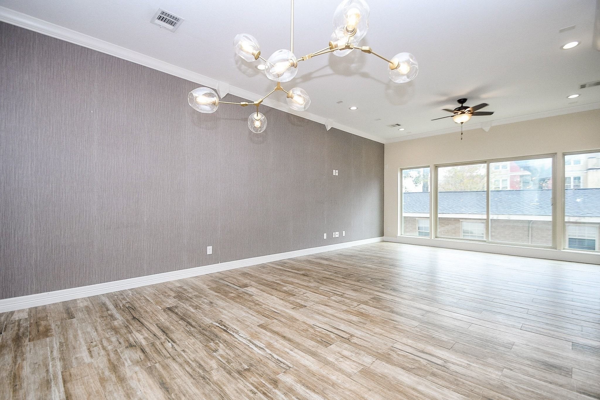 710 Stanford Street, Unit B Houston, TX 77019 - Photo 10 of 33 a view of an empty room with a window and wooden floor
