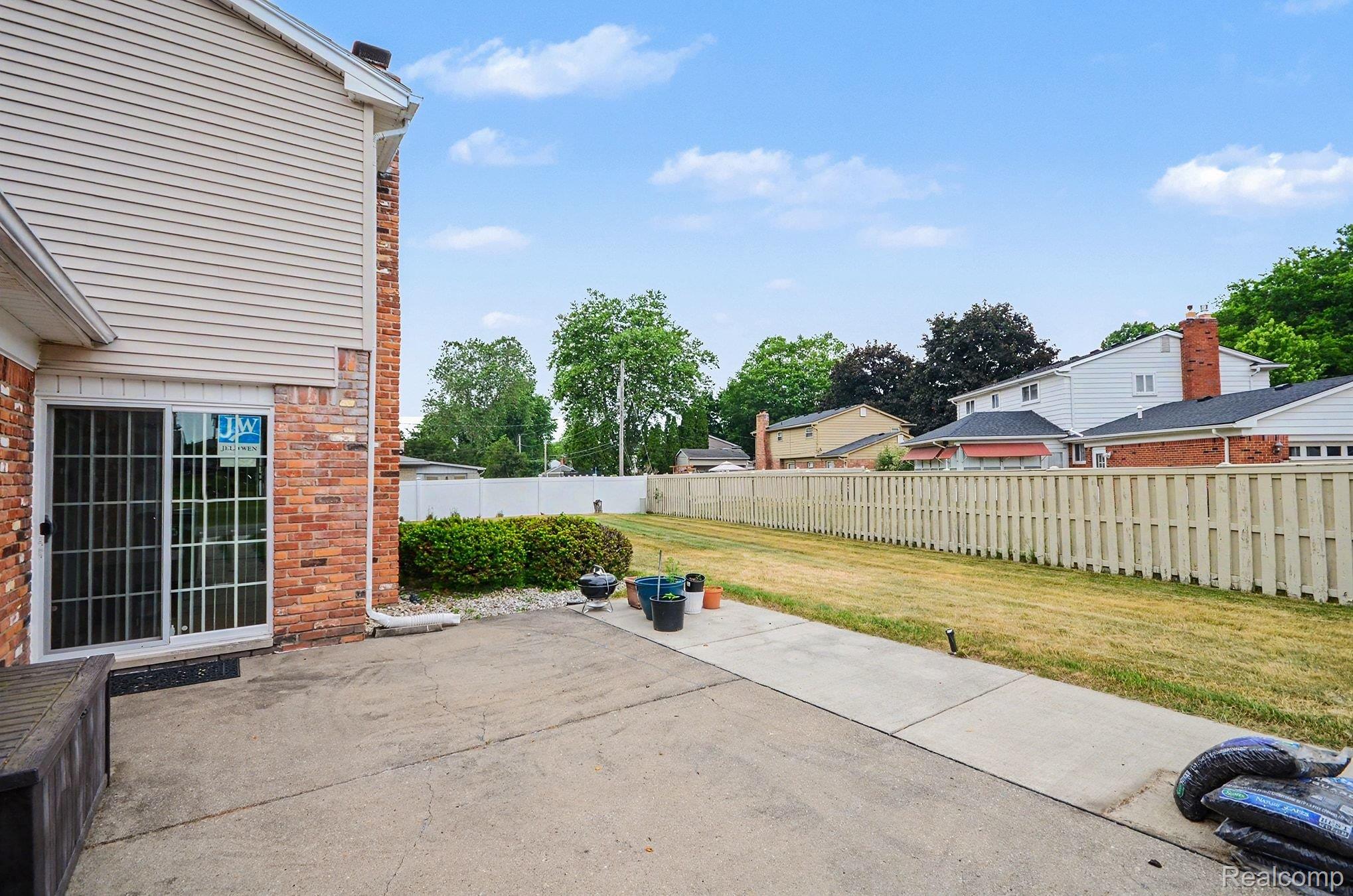 6653 Flintlock Ridge Utica, MI 48317 - Photo 25 of 31 Expansive concrete patio with brick and siding exterior