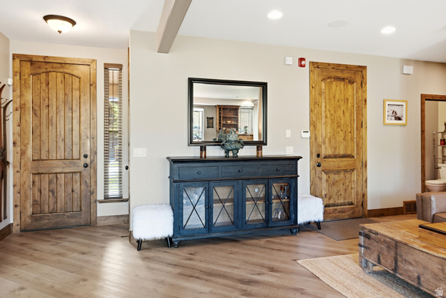 3148 Lower Saddleback Road Park City, UT 84098 - Photo 20 of 67 Entryway featuring wood-finish flooring, a wood plank door with an arched top panel, and a vertical window with blinds