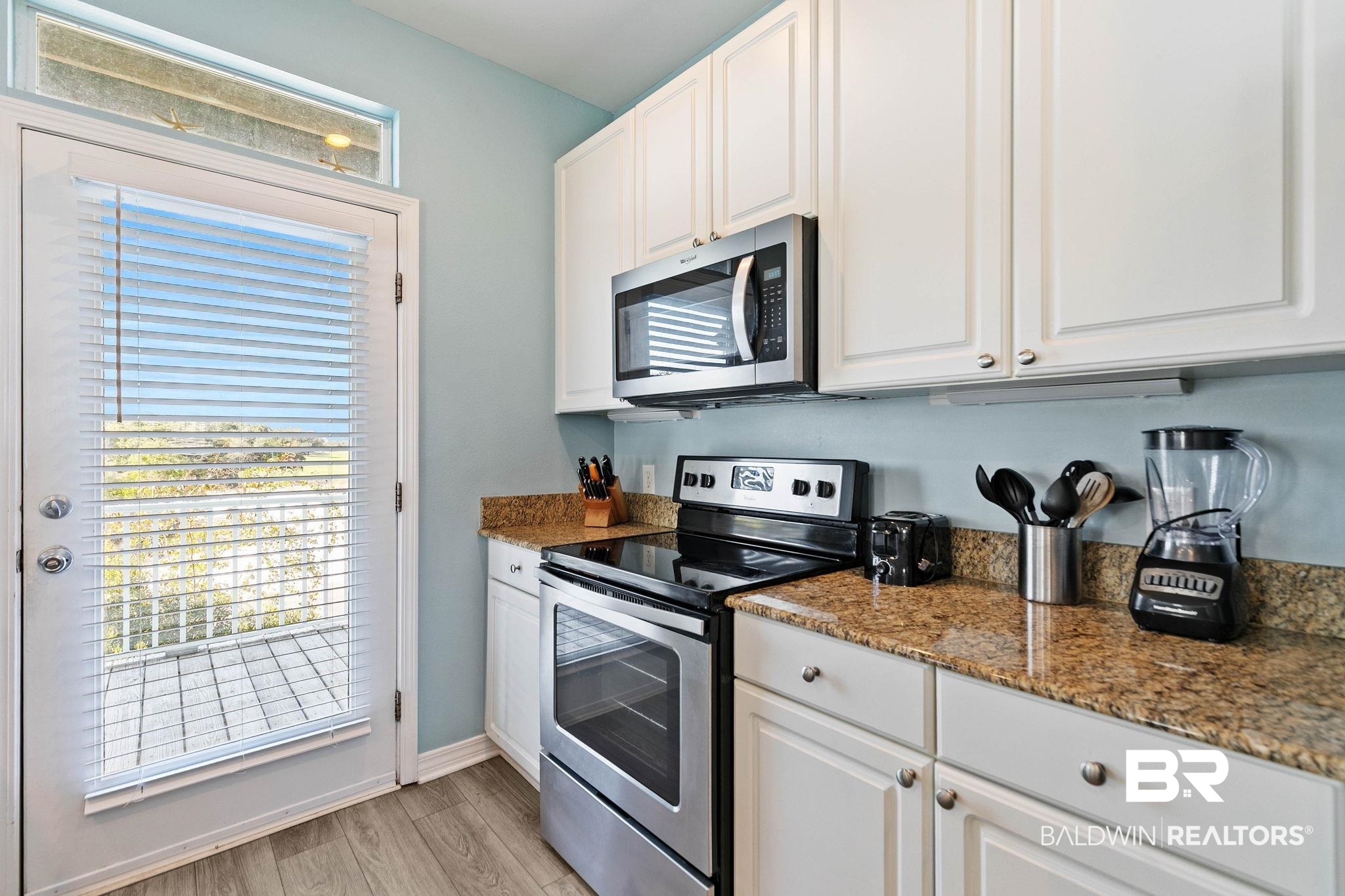 545 Plantation Road, Unit 3 Gulf Shores, AL 36542 - Photo 16 of 54 Kitchen with stainless steel appliances, white cabinets, dark stone countertops, and light wood-type flooring