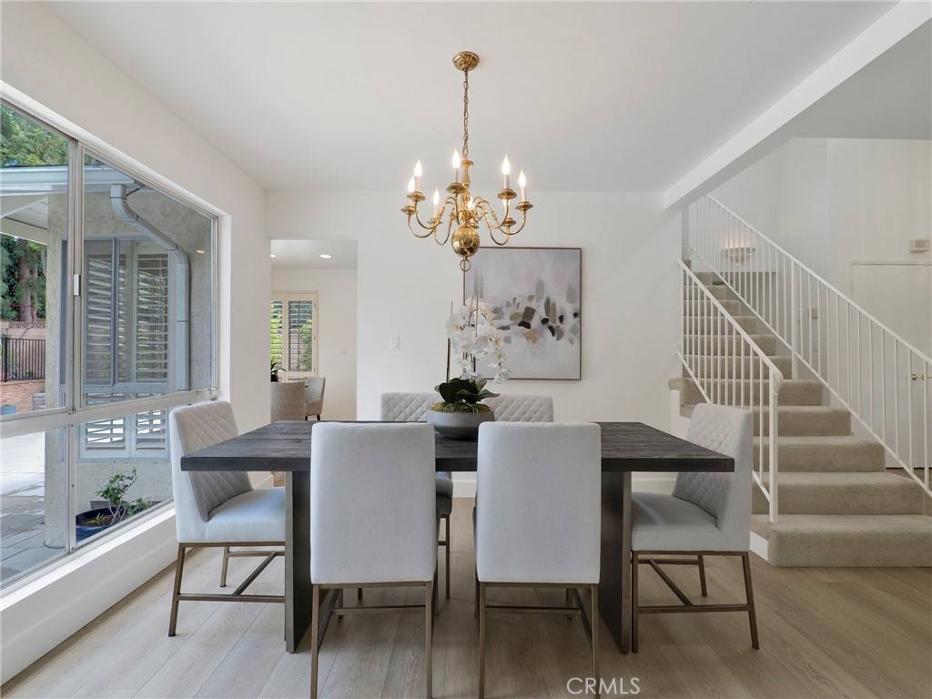22649 Town Crier Road Calabasas, CA 91302 - Photo 13 of 47 a dining room with furniture a chandelier and wooden floor
