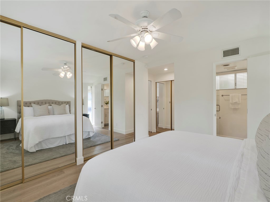 22649 Town Crier Road Calabasas, CA 91302 - Photo 15 of 47 a spacious bedroom with a large bed and a chandelier