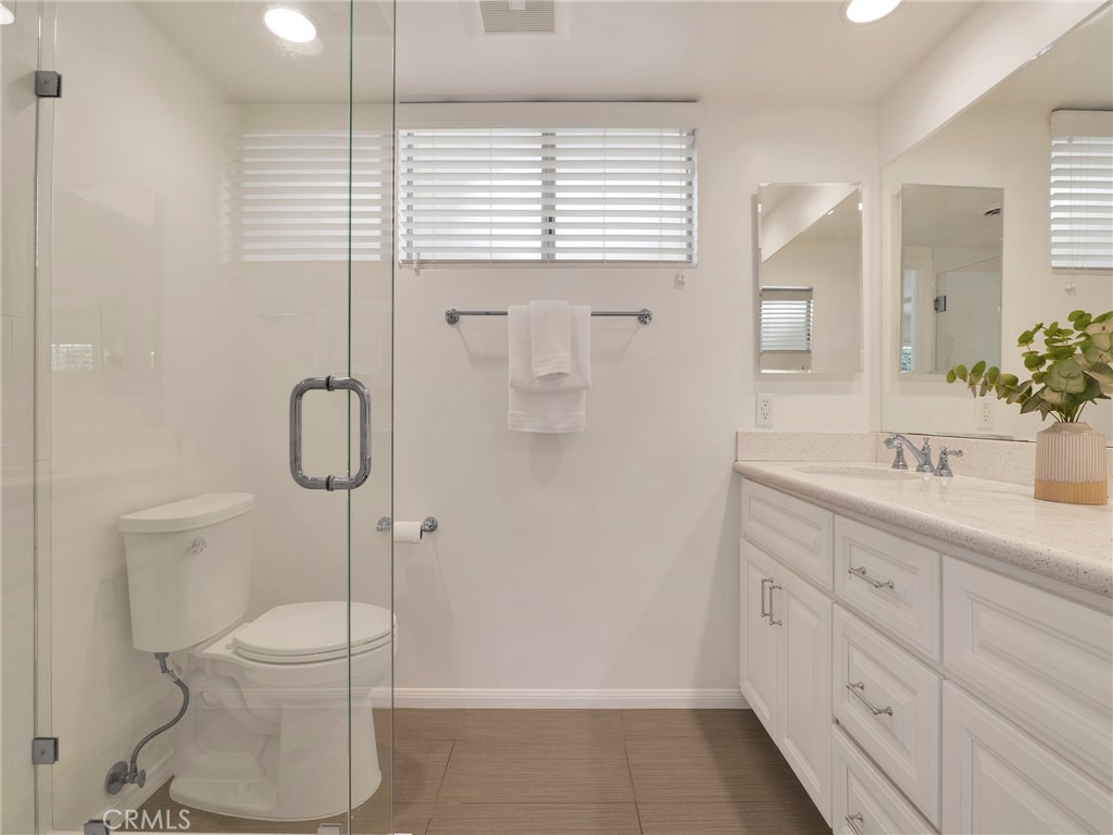 22649 Town Crier Road Calabasas, CA 91302 - Photo 16 of 47 a bathroom with a granite countertop sink a toilet and a shower