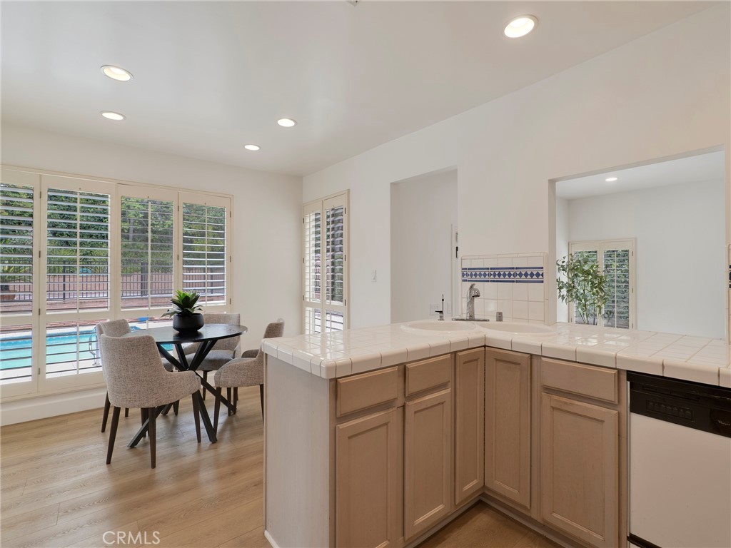 22649 Town Crier Road Calabasas, CA 91302 - Photo 29 of 47 a kitchen with a sink dining table and chairs