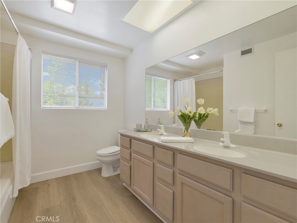 22649 Town Crier Road Calabasas, CA 91302 - Photo 33 of 47 a bathroom with a toilet a sink and mirror