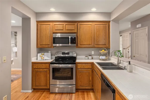 a kitchen with stainless steel appliances a stove sink and microwave