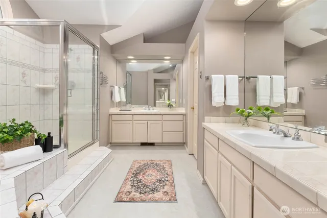 a bathroom with a double vanity sink mirror and shower
