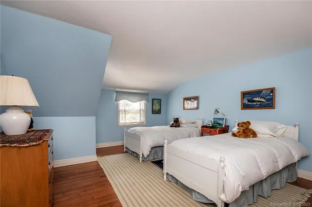 a bed room with two beds and a lamp