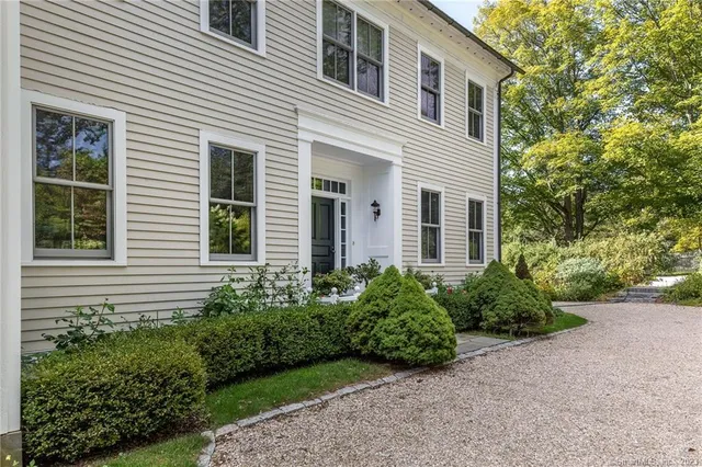 a view of a house with brick walls and a yard with plants