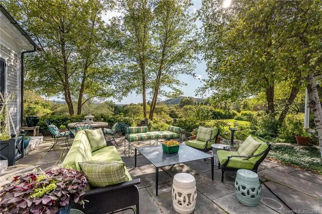 a view of a patio with couches table and chairs and potted plants